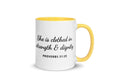 White ceramic mug with yellow handle and interior, black script text "She is clothed in strength & dignity," Proverbs 31:25