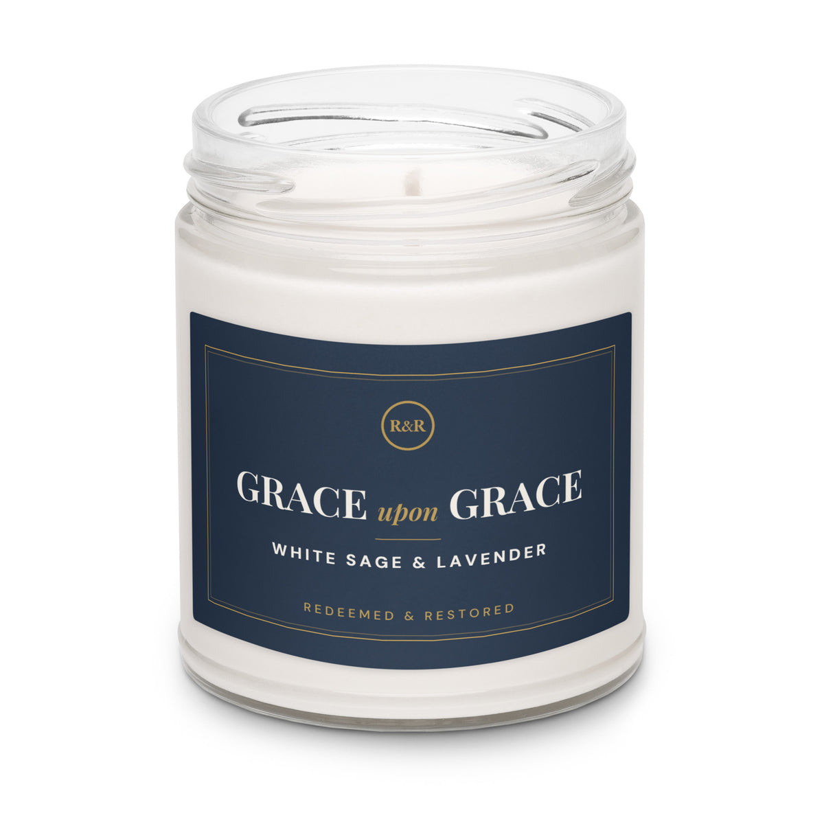 Grace Upon Grace White Sage & Lavender soy candle with the lid removed, showing white wax and wick in a clear glass jar