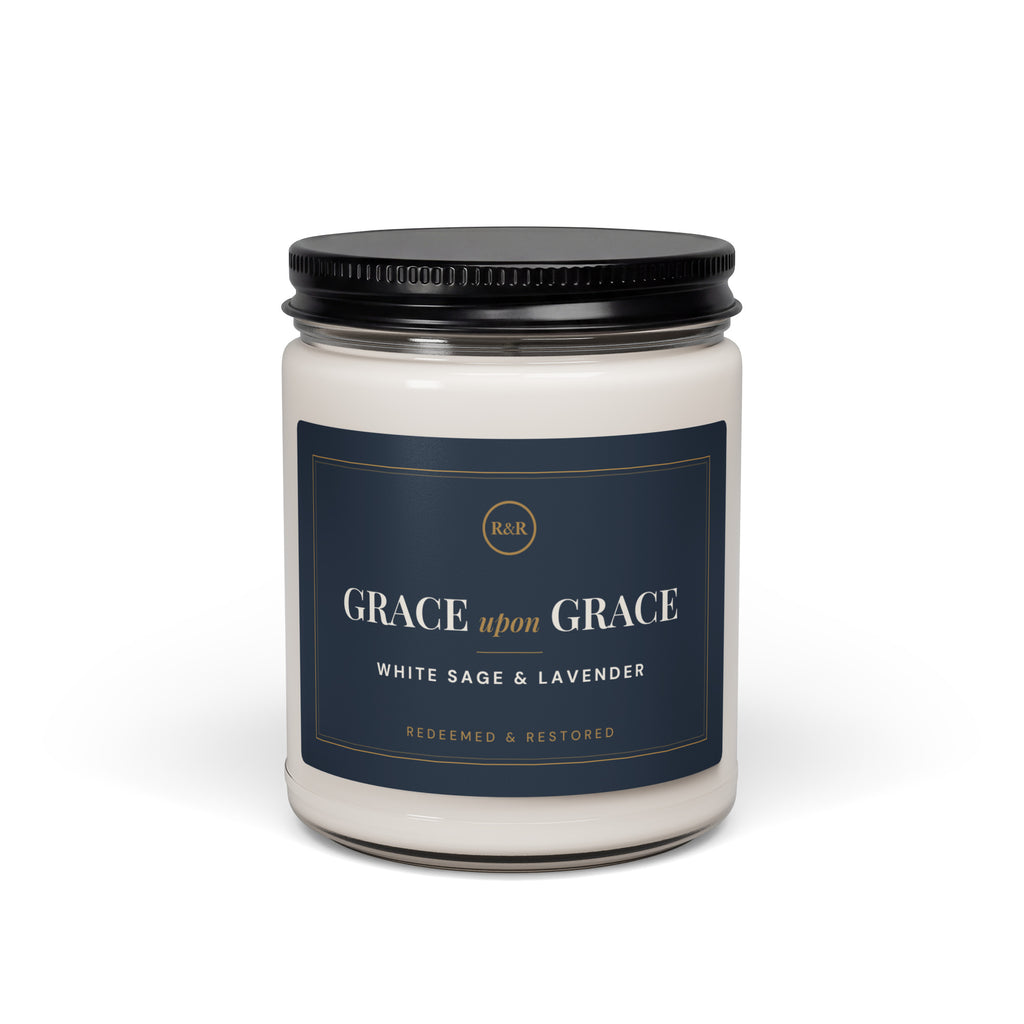 Grace Upon Grace White Sage & Lavender candle in a glass jar with black lid and navy and gold label, front view